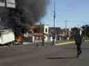 Des hommes transportent des meubles après avoir pillé un magasin, alors qu'un camion brûle dans une rue de Culiacan, dans l'État de Sinaloa, le jeudi 5 janvier 2023. 