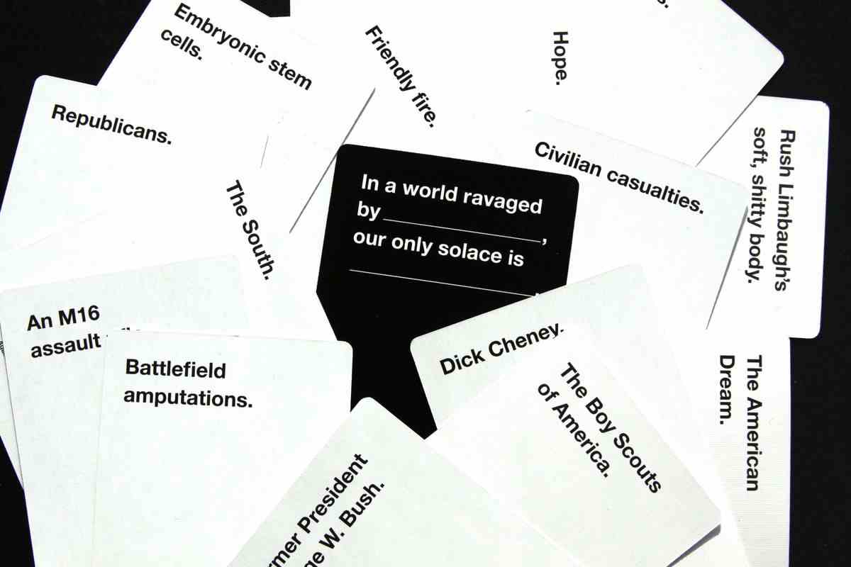 cartes contre les cartes de l'humanité assis sur une table.  la carte noire se lit comme suit : 