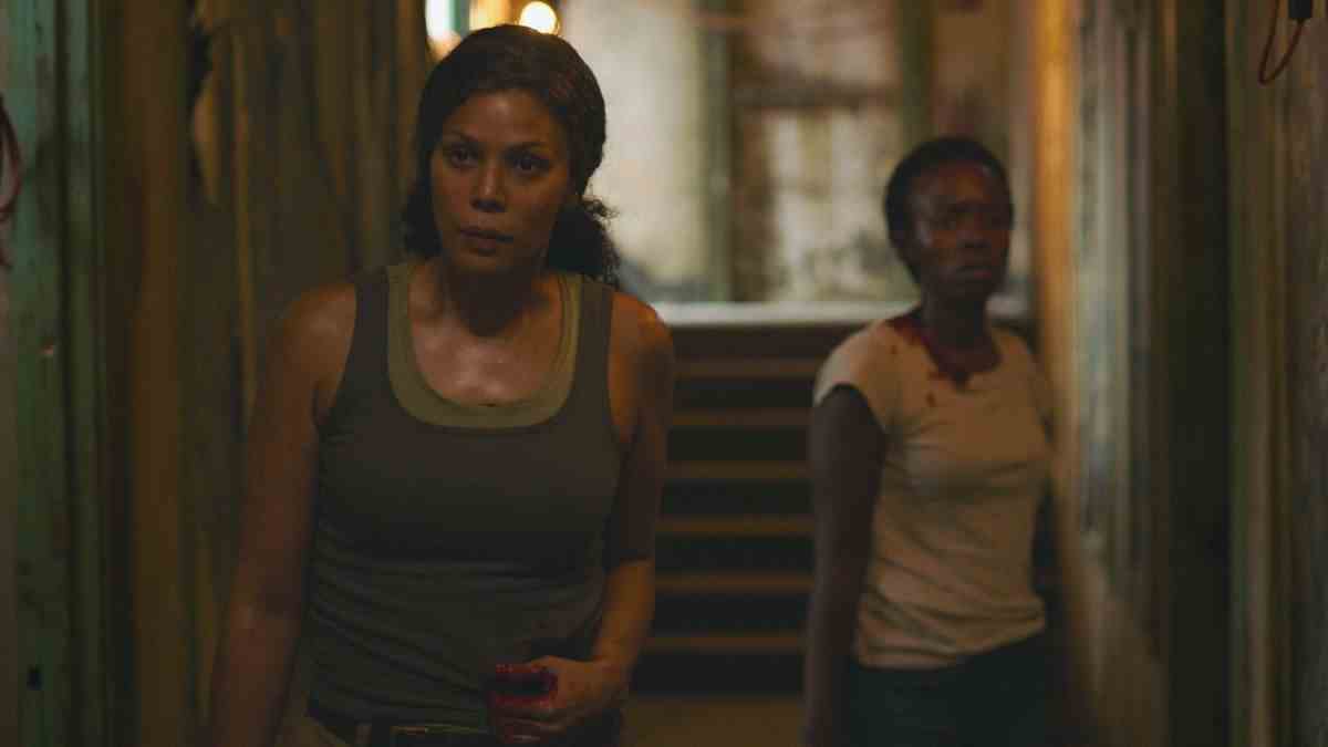 Marlene et Kim, deux lucioles, se tiennent blessées dans un couloir sombre face à la caméra dans la série HBO The Last of Us