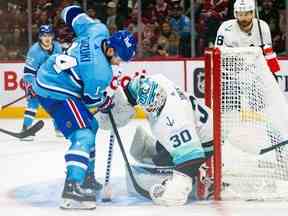 Nick Suzuki des Canadiens n'arrive pas à mettre son bâton sur une rondelle libre devant le gardien de Seattle Kraken Martin Jones lors de la troisième période d'un match de la Ligue nationale de hockey à Montréal le lundi 9 janvier 2023.