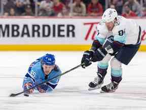 Michael Pezzetta des Canadiens plonge pour une rondelle libre derrière Daniel Sprong des Seattle Kraken lors de la deuxième période d'un match de la Ligue nationale de hockey à Montréal le lundi 9 janvier 2023.