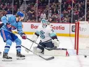 Christian Dvorak des Canadiens voit son tir dévié par le gardien du Seattle Kraken Martin Jones lors de la première période d'un match de la Ligue nationale de hockey à Montréal le lundi 9 janvier 2023.