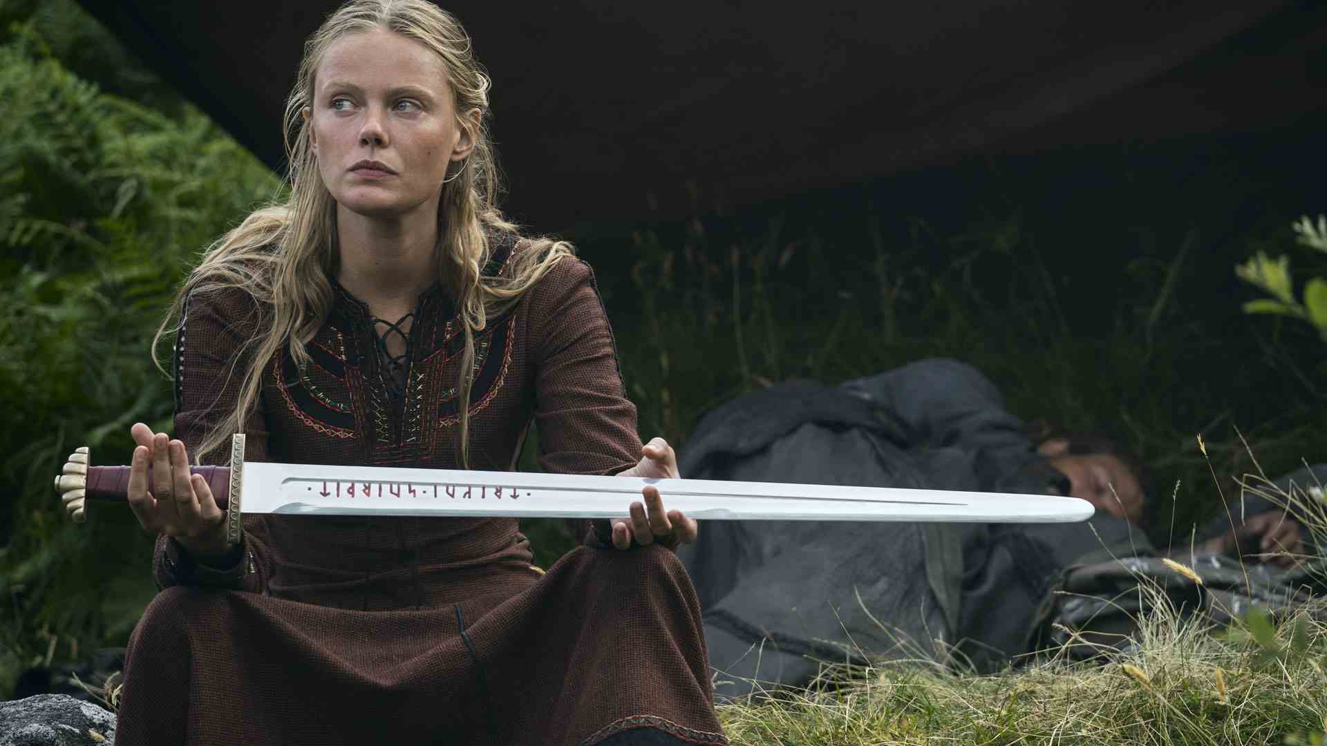 Freydis tient son épée en l'air à quelqu'un hors écran dans Vikings Valhalla saison 2