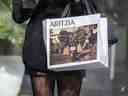 Une femme tenant un sac à provisions Aritzia marchant sur la rue Bloor Ouest de Toronto pendant la pandémie COVID-19.