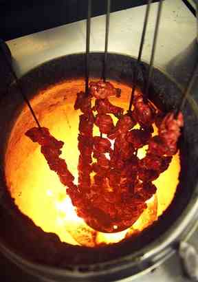 Des brochettes de poulet sont rôties pendant le processus de fabrication du poulet Tikka Masala au restaurant Shish Mahal à Glasgow, en Écosse, le 29 juillet 2009. (Andy Buchanan/AFP/Getty Images)