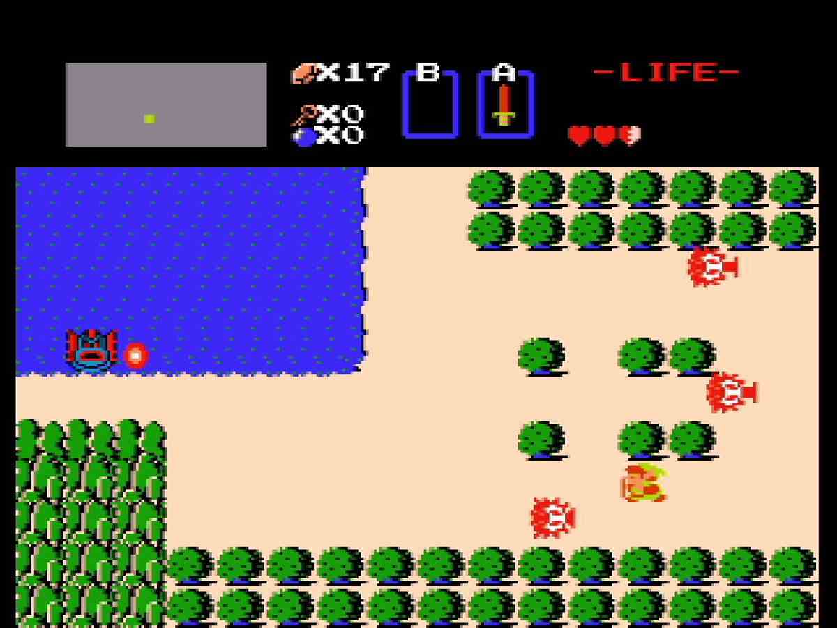 Des graphiques simples montrent Link parmi les buissons près d'un lac, avec des ennemis autour