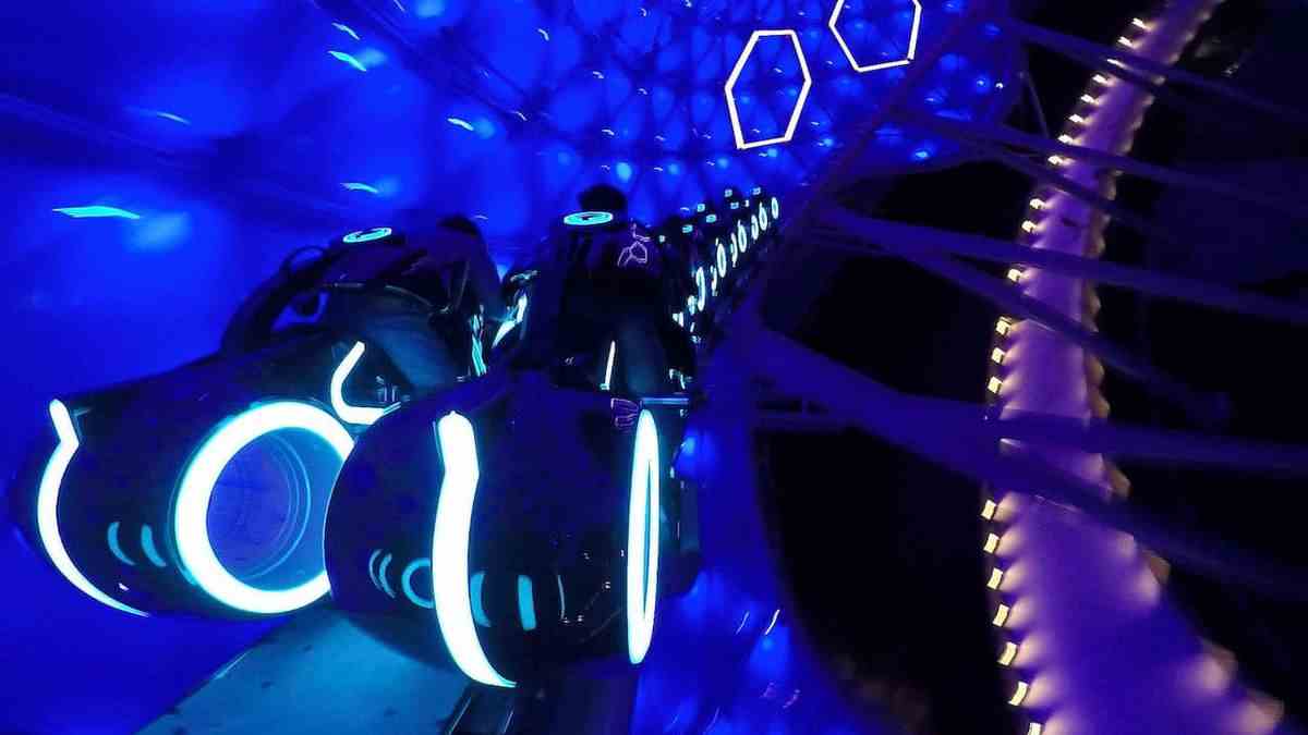Les coureurs voyagent sur des lightcycles Tron à travers un auvent bleu dans la version Shanghai Disney de TRON Lightcycle / Run 
