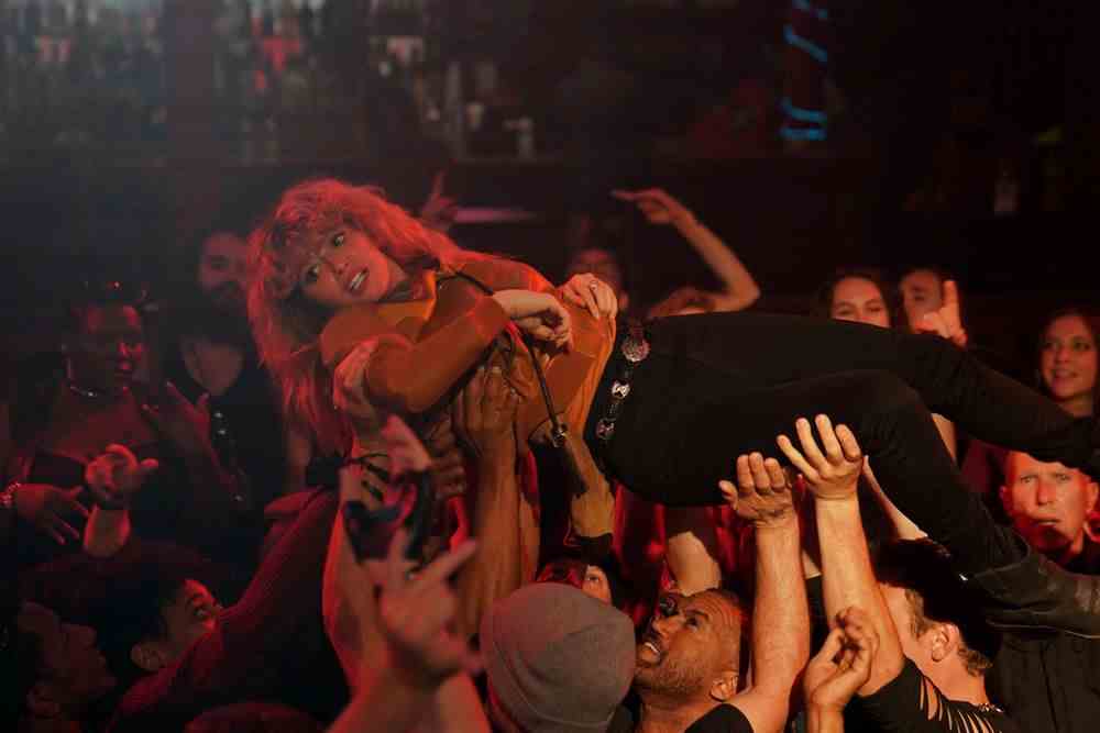 Charlie (Natasha Lyonne) se fait porter par une foule de métalleux en délire dans Poker Face