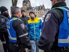 Mathieu Venne de Val-des-Monts, au Québec, s'entretient samedi avec des agents de liaison du Service de police d'Ottawa sur la Colline du Parlement.