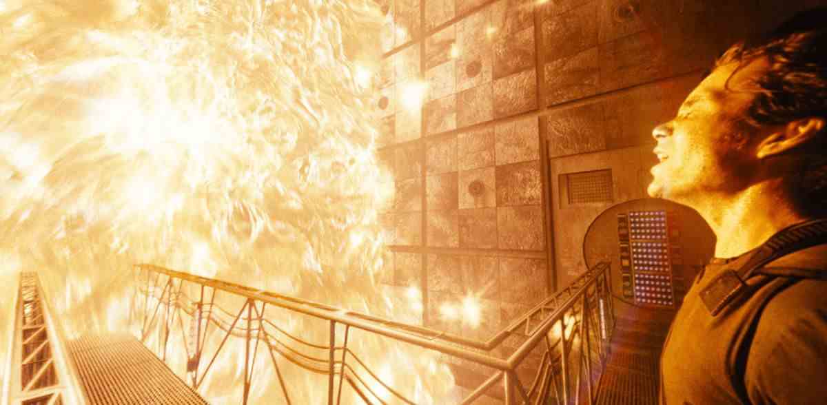 Un homme (Cillian Murphy) debout sur le pont intérieur d'un vaisseau spatial se préparant à être englouti par un mur de flammes.