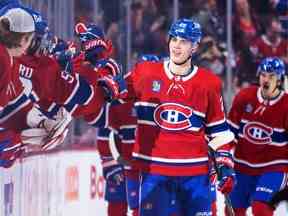 Juraj Slafkovsky des Canadiens obtient un high five de ses coéquipiers après avoir marqué son premier but en carrière contre les Coyotes de l'Arizona lors de la deuxième période du match de la Ligue nationale de hockey à Montréal le jeudi 20 octobre 2022.