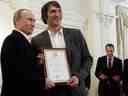 (FICHIERS) Dans cette photo d'archive prise le 29 mai 2012, le président russe Vladimir Poutine (R) détient un certificat, ainsi que le membre de l'équipe nationale russe de hockey sur glace Alexander Ovechkin (2e L), remerciant Ovechkin pour ses efforts pour aider la Russie à gagner le Championnat du monde 2012.