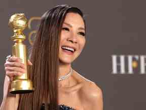Michelle Yeoh pose avec son prix de la meilleure actrice dans un film musical ou comique pour 