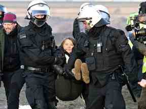 Des policiers éloignent la militante climatique suédoise Greta Thunberg du bord de la mine de lignite à ciel ouvert de Garzweiler II lors d'une action de protestation des militants du climat, à Luetzerath, en Allemagne, le mardi 17 janvier 2023.