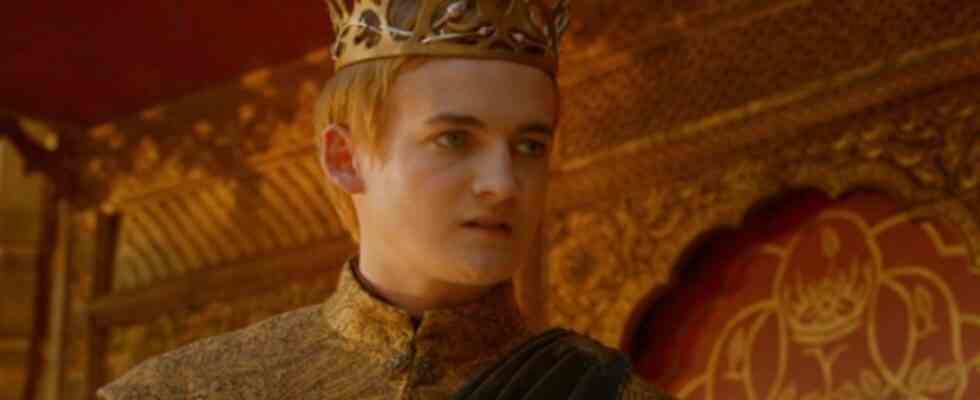 Jack Gleeson as Joffrey standing wearing a crown on Game of Thrones