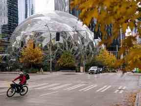 Un livreur passe devant Amazon Spheres, qui fait partie du campus du siège social d'Amazon, dans le quartier South Lake Union de Seattle, Washington.