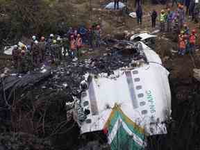 Les sauveteurs parcourent le site de l'accident dans l'épave d'un avion de ligne à Pokhara, au Népal, le lundi 16 janvier 2023.
