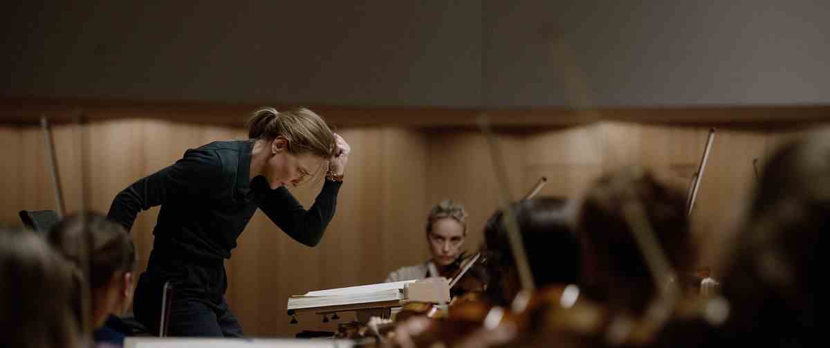 Lydia Tár (Cate Blanchett) fait un geste vigoureux de tout le corps vers le bas tout en dirigeant l'Orchestre philharmonique de Berlin dans Tár de Todd Field