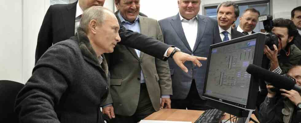 Vladimir Putin being shown something on a computer monitor