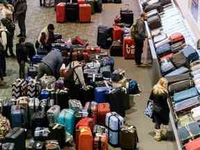 Les sacs à bagages sont amassés dans la zone de récupération des bagages de l'aéroport international Pearson de Toronto, alors qu'une importante tempête hivernale perturbe les vols à destination et en provenance de l'aéroport, à Toronto, le 24 décembre 2022.