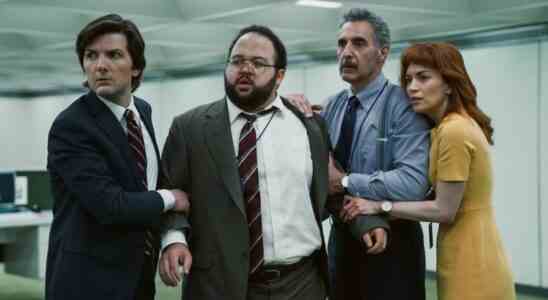 A group of employees in an office space huddle together as if in defense; still from "Severance."