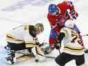 Le gardien de but des Bruins de Boston Jeremy Swayman arrête Alex Belzile des Canadiens de Montréal alors que Charlie McAvoy défend en troisième période à Montréal le 24 janvier 2023.