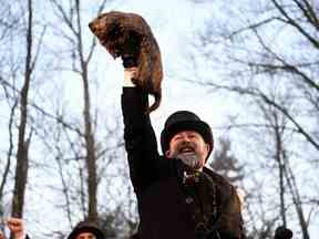 AJ Dereume tient Phil la marmotte alors qu'il doit faire sa prédiction sur la durée de l'hiver pendant les festivités du jour de la marmotte, à Gobblers Knob à Punxsutawney, Pennsylvanie, le 2 février 2023.