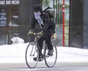 Un messager à vélo roule dans le vent par une journée extrêmement froide et venteuse à Montréal le vendredi 3 février 2023.