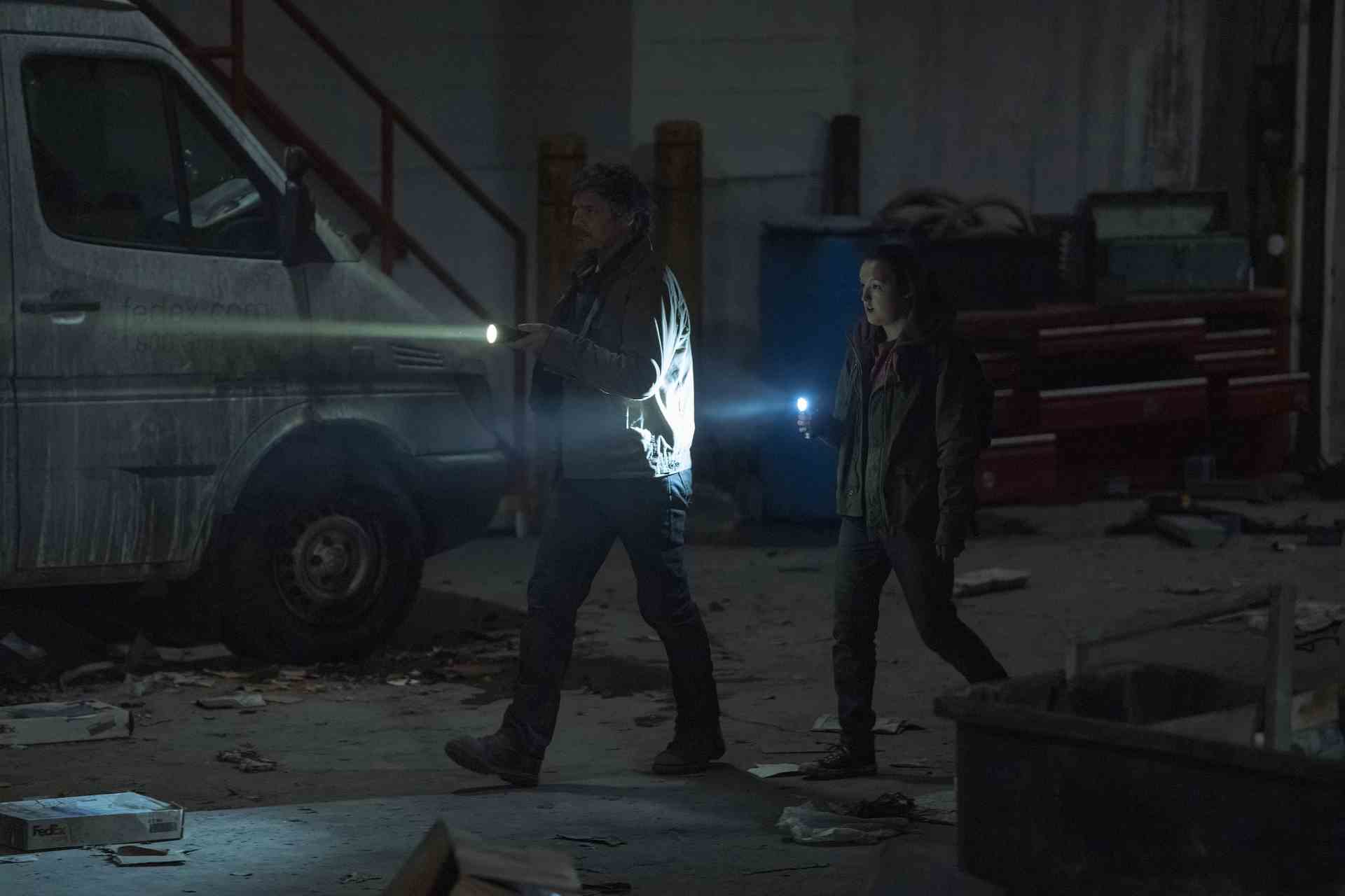(De gauche à droite) Pedro Pascal (comme Joel) et Bella Ramsey (comme Ellie) passent devant une voiture dans l'épisode 4 de The Last of Us de HBO