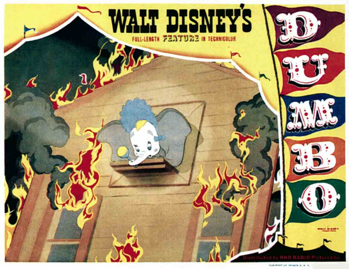 Une carte de lobby de 1941 de Dumbo de Walt Disney, avec l'éléphant titulaire aux grandes oreilles maquillé de clown et un bonnet de bébé, regardant par la fenêtre d'une maison en feu, bordée par le traitement du titre du film et le rabat ouvert d'une tente de cirque