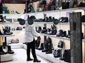 Une femme visite un magasin de chaussures dans le centre de Moscou.
