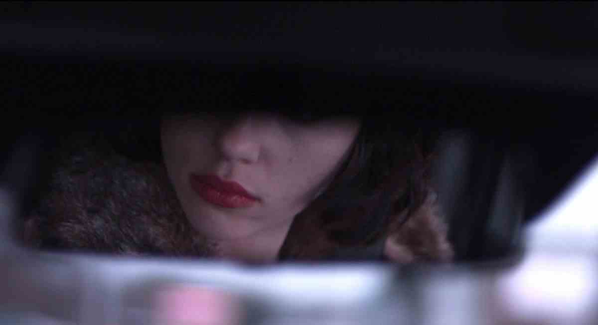 Un rétroviseur montre la moitié inférieure du visage de Scarlett Johansson dans Under the Skin