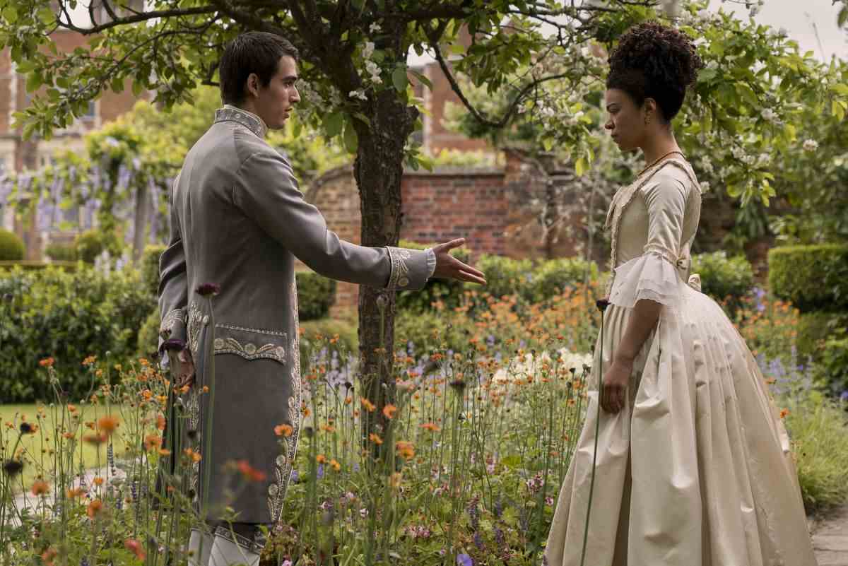le roi george tend la main à une jeune reine charlotte dans un jardin