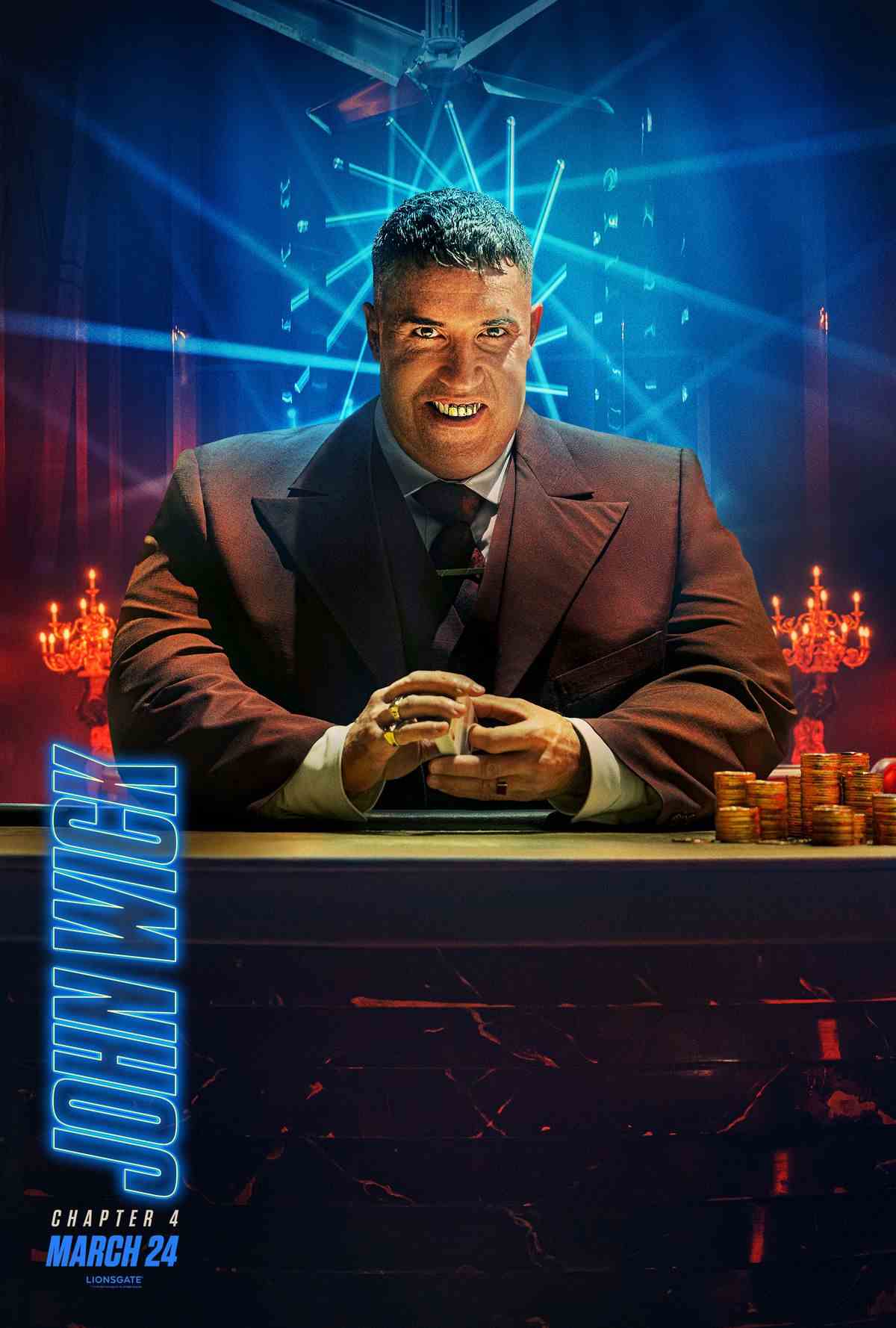 Scott Adkins, dans une grande combinaison prothétique, affiche un sourire taché de tabac alors qu'il est assis à un bureau avec un jeu de cartes à la main et une pile de pièces d'or à ses côtés.
