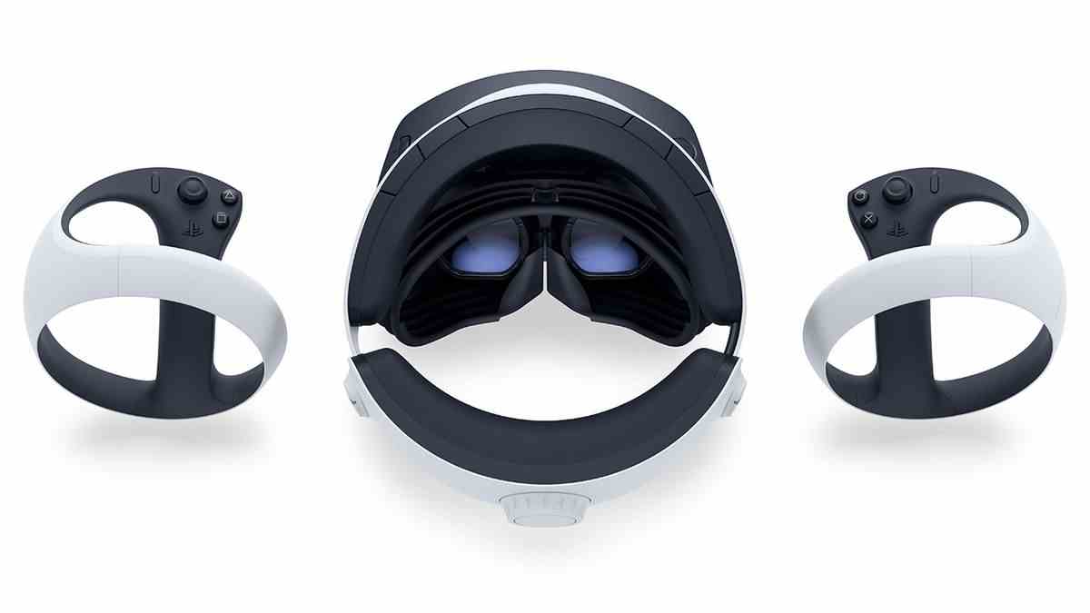 Le casque PSVR 2, vu d'en haut, posé sur une surface blanche, flanqué des deux contrôleurs VR2 Sense