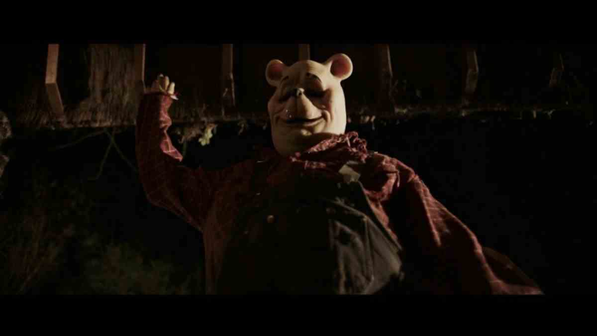 Pooh (Craig David Dowsett) se précipite vers le haut pour poignarder une victime hors écran dans Winnie the Pooh: Blood and Honey