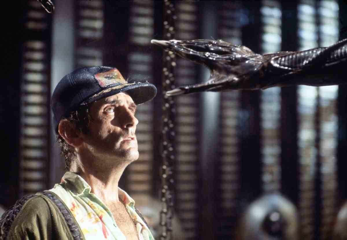 L'acteur Harry Dean Stanton sur le tournage d'Alien de 1979, levant les yeux avec effroi alors que la main du Xénomorphe se tend la tête