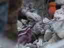 Un secouriste creuse pour atteindre un garçon sous les décombres d'un immeuble effondré dans la ville rebelle de Jindayris le 8 février 2023, deux jours après un tremblement de terre meurtrier qui a frappé la Turquie et la Syrie.