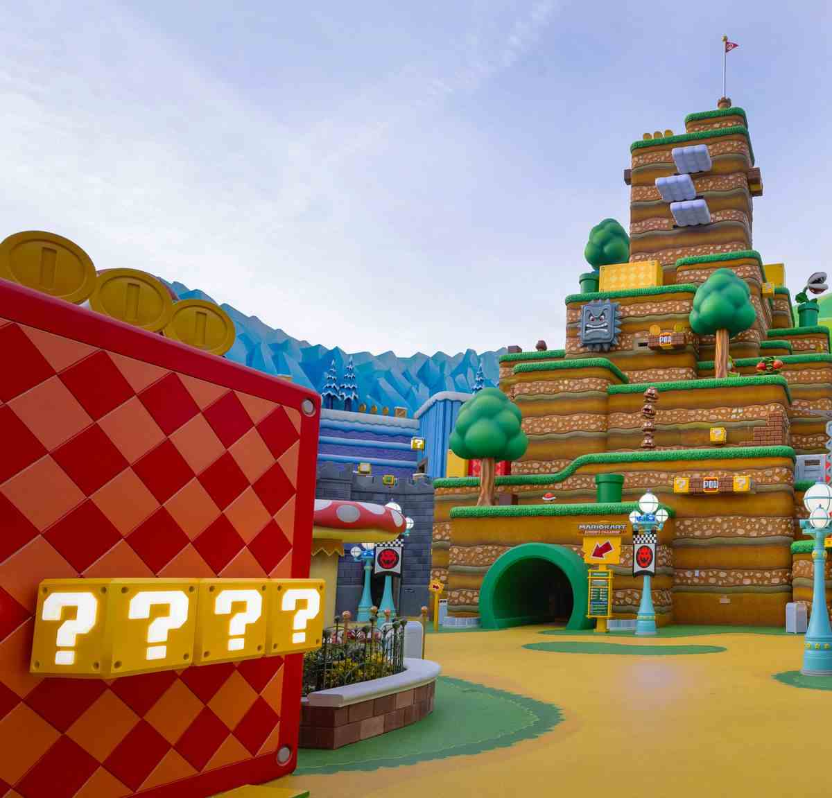 L'entrée de Mario Kart : Bowser's Challenge au Super Nintendo World à Universal Studios Hollywood.  Un grand morceau de décor émule l'apparence d'un niveau de Super Mario Bros., avec beaucoup de blocs de pièces, de blocs POW et de Thwomps tachetés partout.