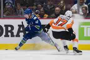 Le défenseur des Flyers de Philadelphie Tony DeAngelo (77) défend contre l'attaquant des Canucks de Vancouver Elias Pettersson (40) en troisième période au Rogers Arena samedi soir.