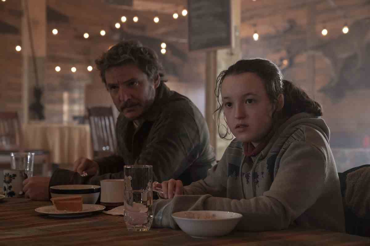 Pedro Pascal et Bella Ramsey sont assis ensemble à une table avec de la nourriture dans The Last of Us.