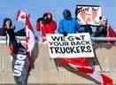Les partisans des camionneurs qui protestent contre le mandat de vaccination du gouvernement libéral et d'autres mesures se rassemblent sur un viaduc sur l'autoroute 416 de l'Ontario alors que le convoi se dirige vers Ottawa le 28 janvier 2022.