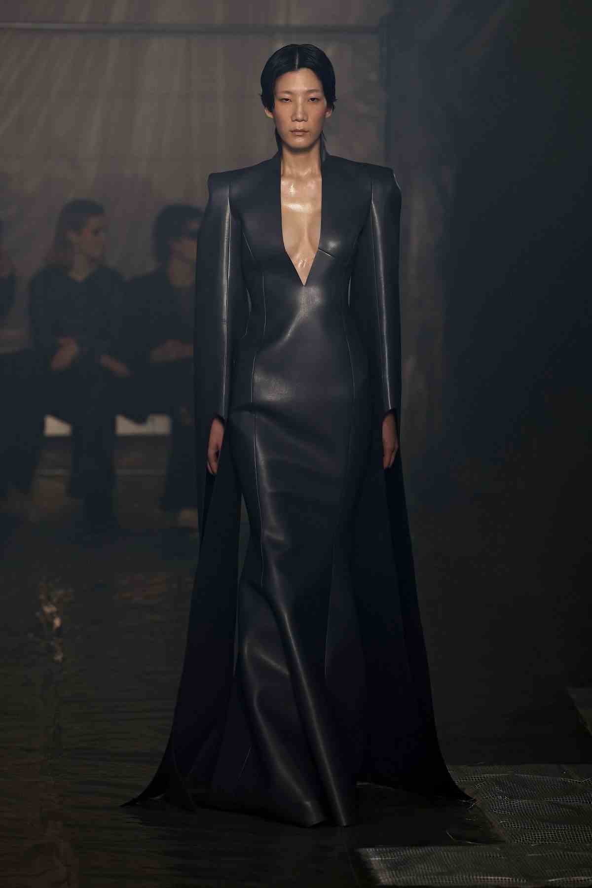 Un mannequin portant une longue robe en cuir noir défile lors du défilé de mode Han Kjobenhavn à la Fashion Week de Milan.