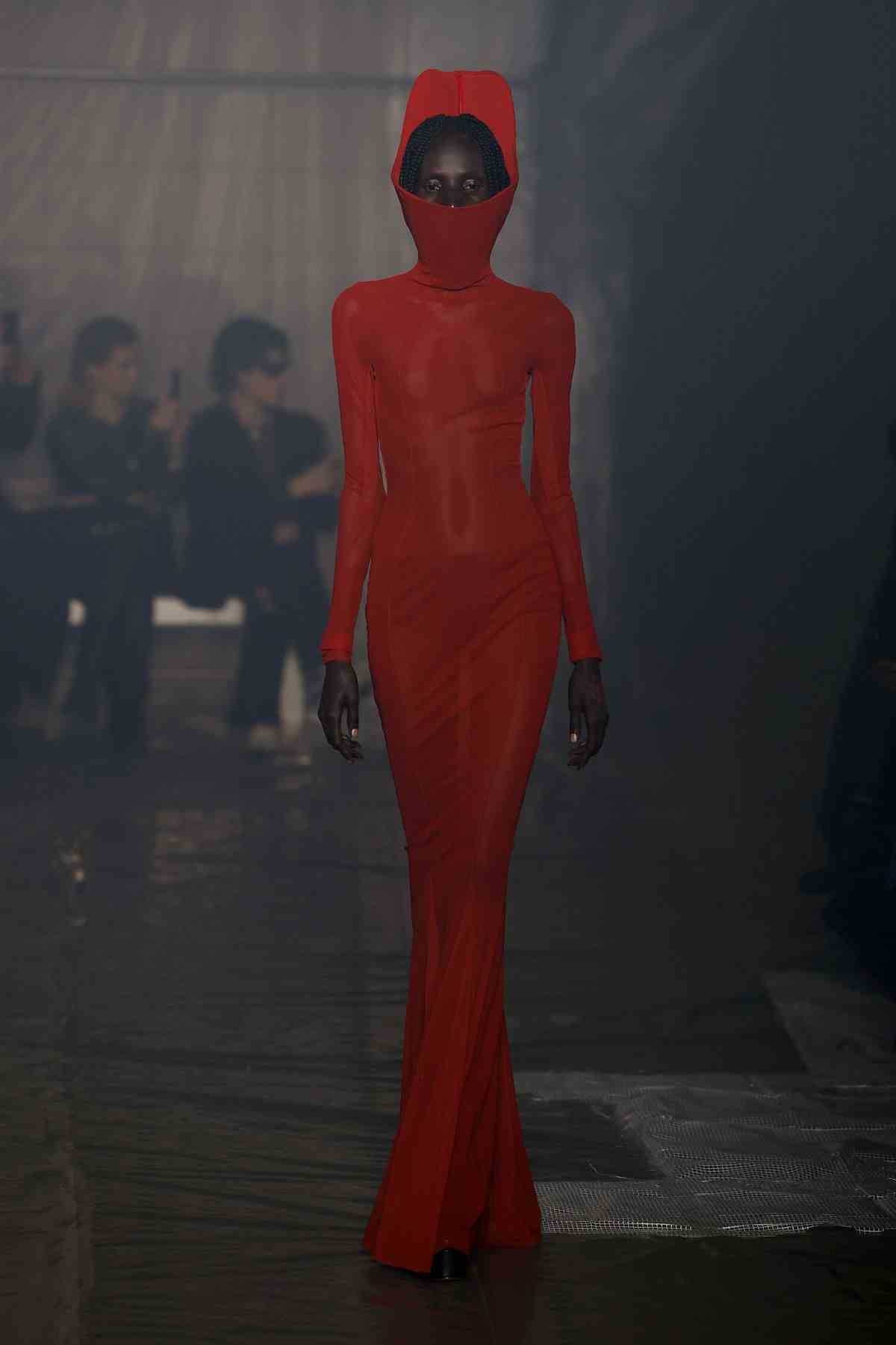 Un mannequin vêtu d'une robe rouge vif avec une capuche défile lors du défilé de mode Han Kjobenhavn à la Fashion Week de Milan.