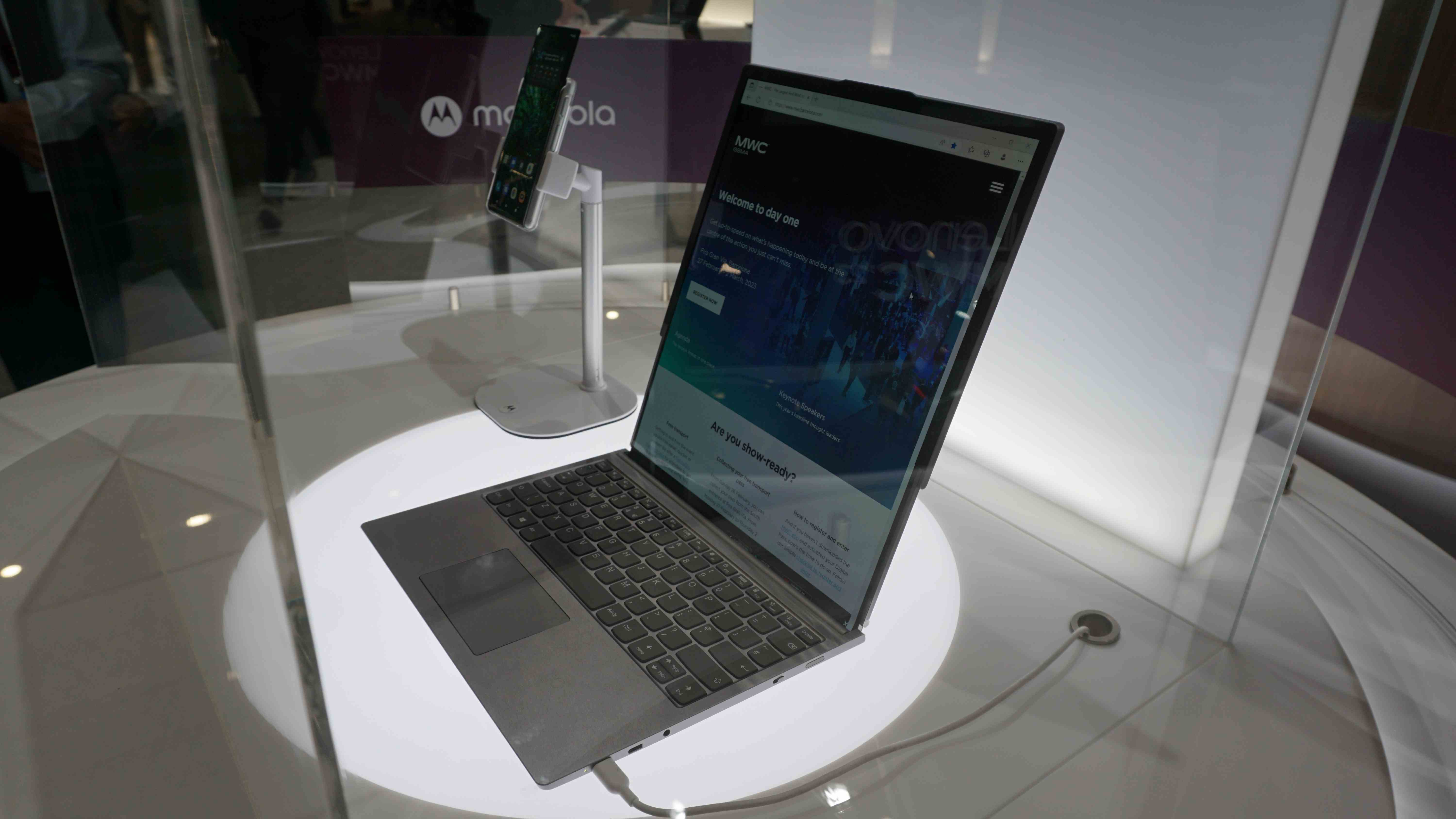 Le concept d'ordinateur portable à technologie enroulable de Lenovo à l'intérieur d'un boîtier en verre.