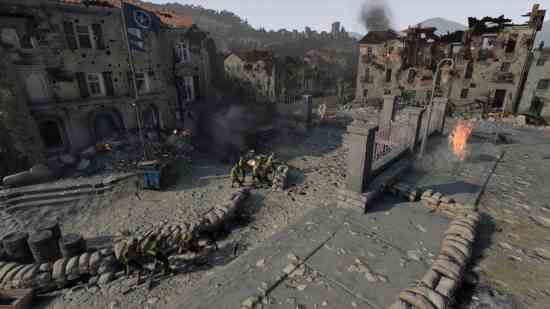 Revue de Company of Heroes 3 : Des soldats se battent dans une ville en ruine boueuse derrière des sacs de sable