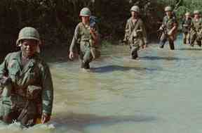 Des soldats américains avancent dans une rizière pendant la guerre du Vietnam.