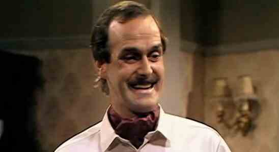 Basil Fawlty smiling in hotel restaurant in Fawlty Towers