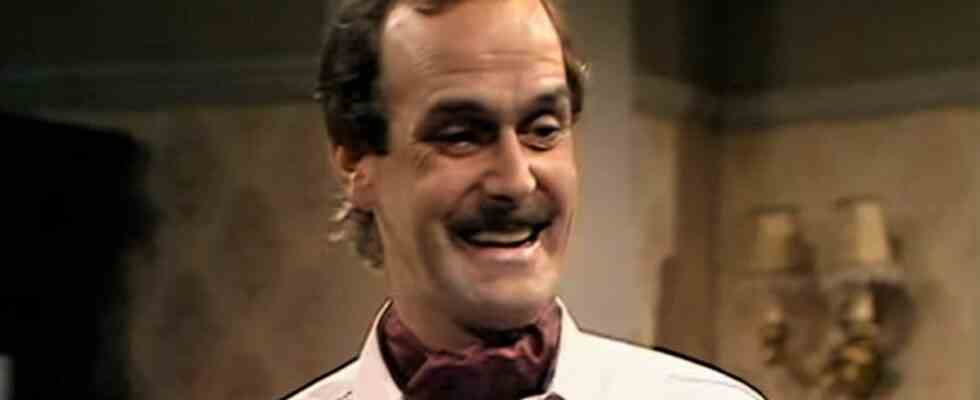 Basil Fawlty smiling in hotel restaurant in Fawlty Towers
