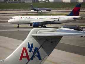Un avion de Delta Air Lines passe devant un avion d'American Airlines à l'aéroport LaGuardia de New York, le lundi 25 avril 2011.
